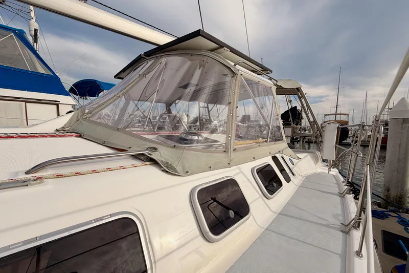 Serendipity II Yacht Photos Pics 2002 Hunter 460 sailboat docked, featuring a clear cockpit enclosure and sleek design.