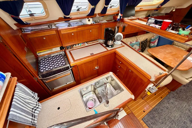 Serendipity II Yacht Photos Pics Interior of 2002 Hunter 460 sailboat kitchen with wood cabinetry and appliances.