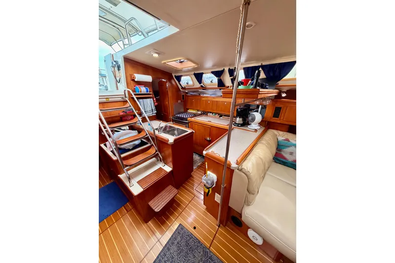 Serendipity II Yacht Photos Pics Interior of 2002 Hunter 460 yacht with wooden cabinetry and cozy seating area.