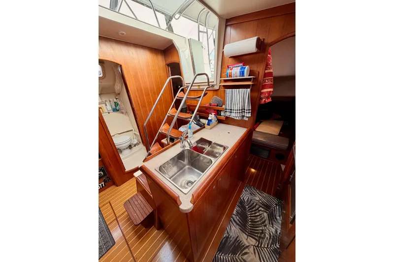 Serendipity II Yacht Photos Pics Interior of 2002 Hunter 460 yacht with wooden cabinetry and compact kitchen area.