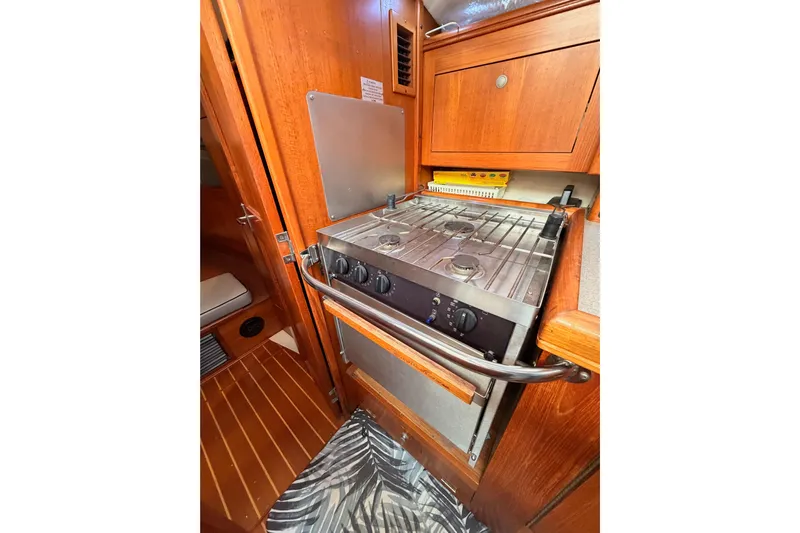 Serendipity II Yacht Photos Pics Compact kitchen area in a 2002 Hunter 460 yacht with stove and wooden cabinetry.