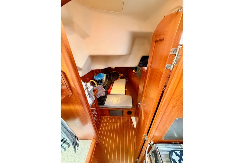 Serendipity II Yacht Photos Pics Interior cabin of 2002 Hunter 460 sailboat with wooden finishes and cozy sleeping area.