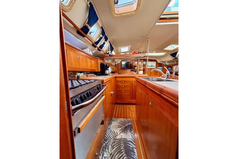 Serendipity II Yacht Photos Pics Interior of 2002 Hunter 460 yacht with wooden cabinetry and modern kitchen amenities.