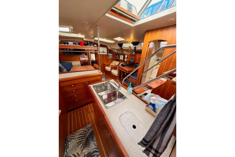 Serendipity II Yacht Photos Pics Interior of 2002 Hunter 460 sailboat, featuring a cozy cabin with wooden finishes.