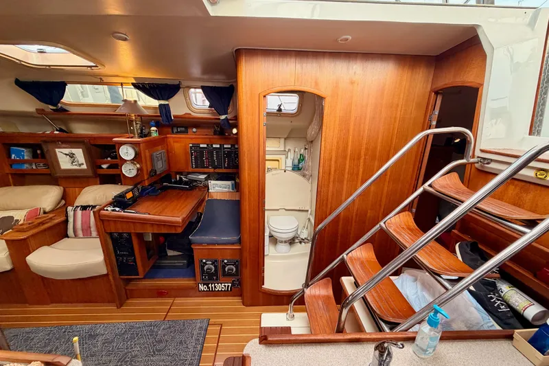 Serendipity II Yacht Photos Pics Interior of 2002 Hunter 460 yacht with wooden finish, navigation station, and compact bathroom.