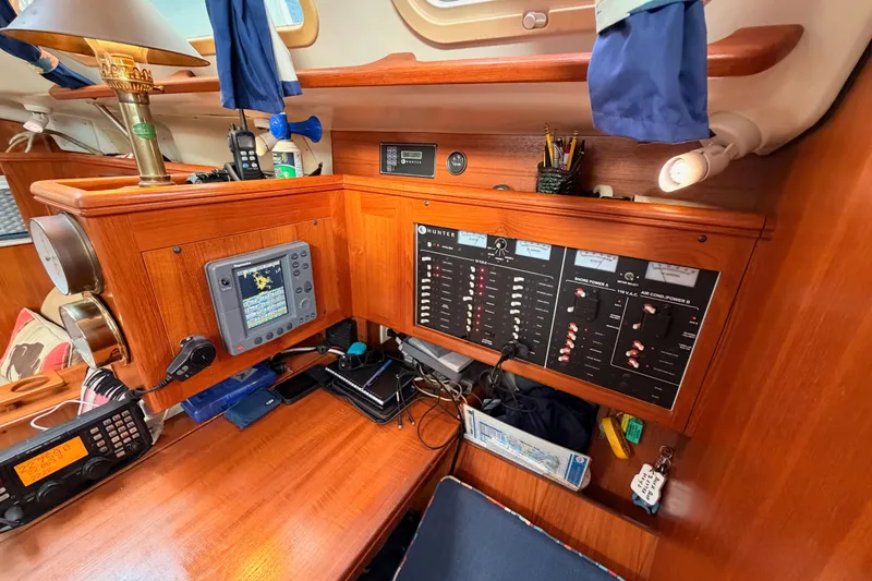 Serendipity II Yacht Photos Pics 2002 Hunter 460 yacht interior with navigation and control panels, wooden finish, and communication equipment.