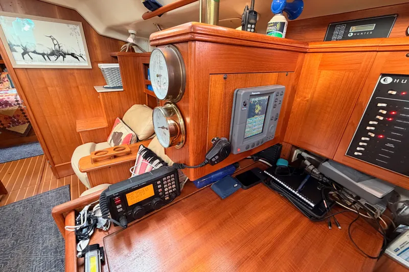 Serendipity II Yacht Photos Pics Interior of 2002 Hunter 460 yacht with navigation equipment and cozy seating area.