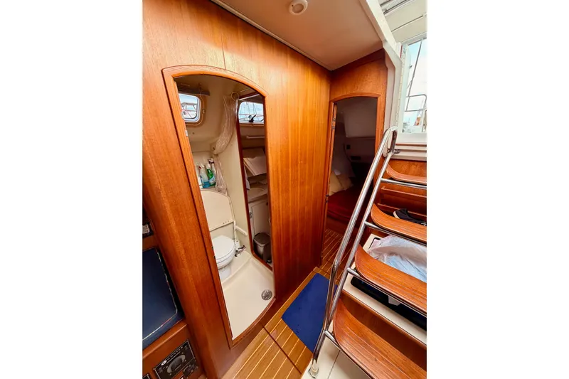 Serendipity II Yacht Photos Pics Interior of 2002 Hunter 460 yacht showing wooden cabinetry and compact bathroom.
