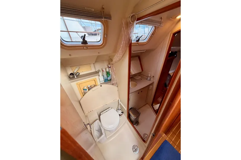 Serendipity II Yacht Photos Pics Bathroom interior of a 2002 Hunter 460 yacht, featuring a toilet, sink, and window.