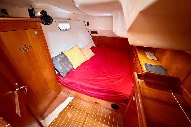 Serendipity II Yacht Photos Pics Cozy cabin interior of 2002 Hunter 460 yacht with red bedding and wooden furnishings.