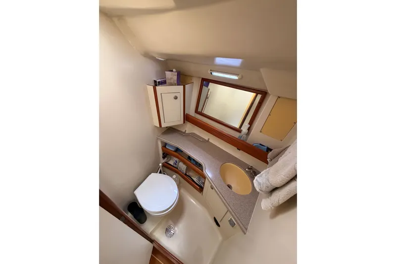 Serendipity II Yacht Photos Pics Compact bathroom in 2002 Hunter 460 yacht with sink, toilet, and storage cabinets.