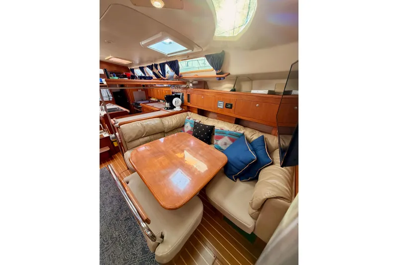 Serendipity II Yacht Photos Pics Interior of 2002 Hunter 460 yacht with cozy seating and wooden table.