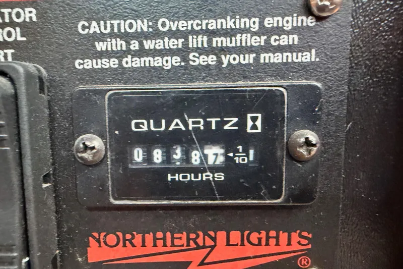 Serendipity II Yacht Photos Pics Hour meter on Northern Lights engine panel, showing 8387.1 hours, with caution text above.