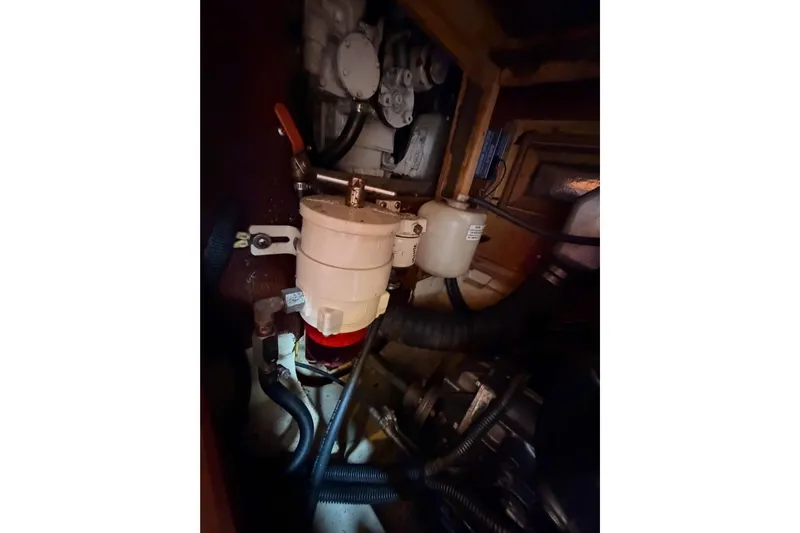 Serendipity II Yacht Photos Pics Engine compartment of a 2002 Hunter 460 sailboat, showing mechanical components and hoses.