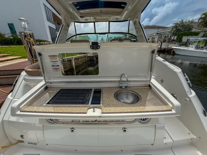  Yacht Photos Pics 2016 Sea Ray 350 Sundancer boat with outdoor kitchenette, featuring a sink and grill.