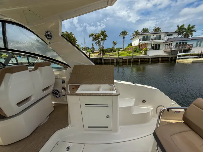  Yacht Photos Pics 2016 Sea Ray 350 Sundancer boat interior with seating and sink, docked near waterfront homes.