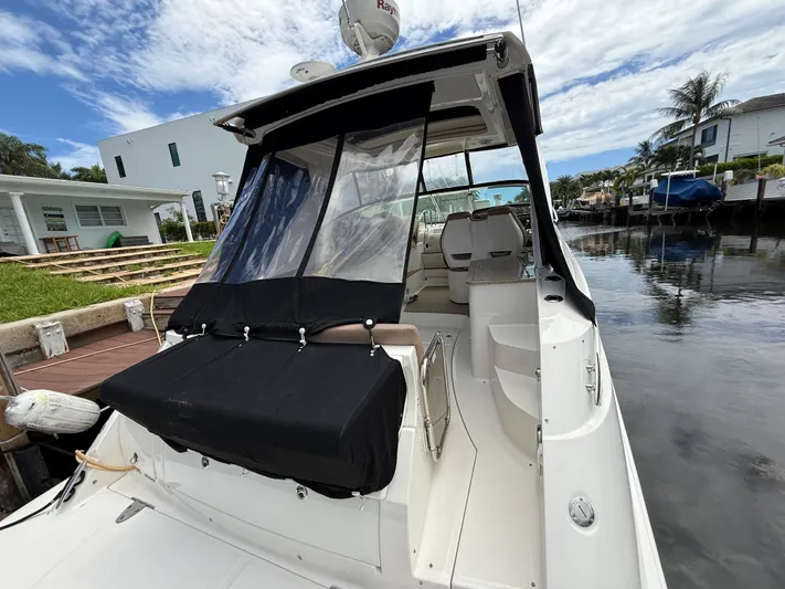  Yacht Photos Pics 2016 Sea Ray 350 Sundancer docked by waterfront homes, featuring covered seating area.
