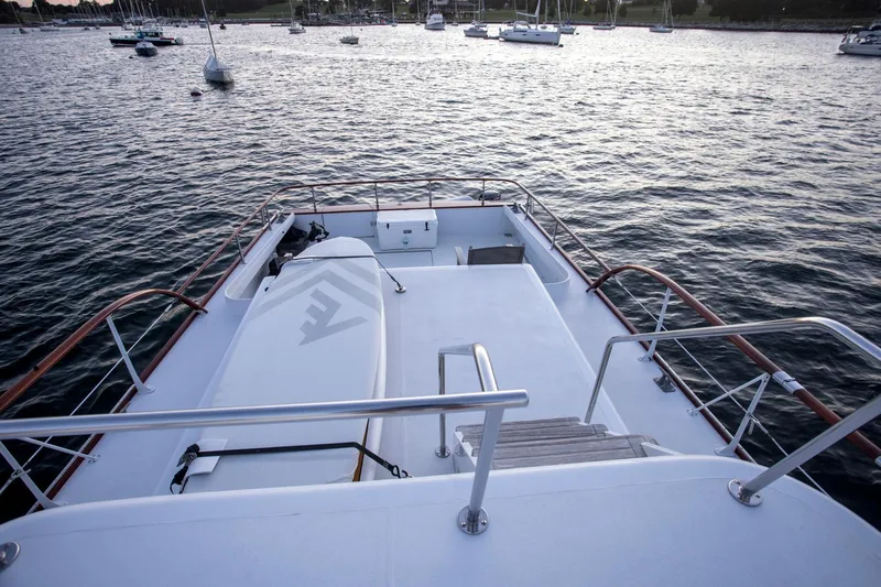 Huckins Yacht Corporation Yacht Photos Pics 1964 Huckins Out Islander 56 yacht deck overlooking calm waters and anchored boats.