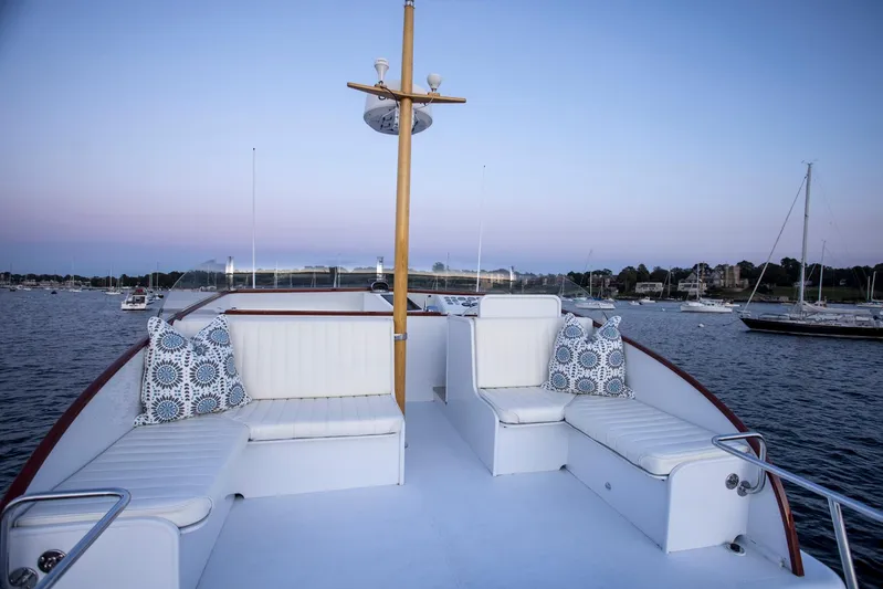 Huckins Yacht Corporation Yacht Photos Pics 1964 Huckins Out Islander 56 yacht deck with seating, overlooking calm waters at sunset.