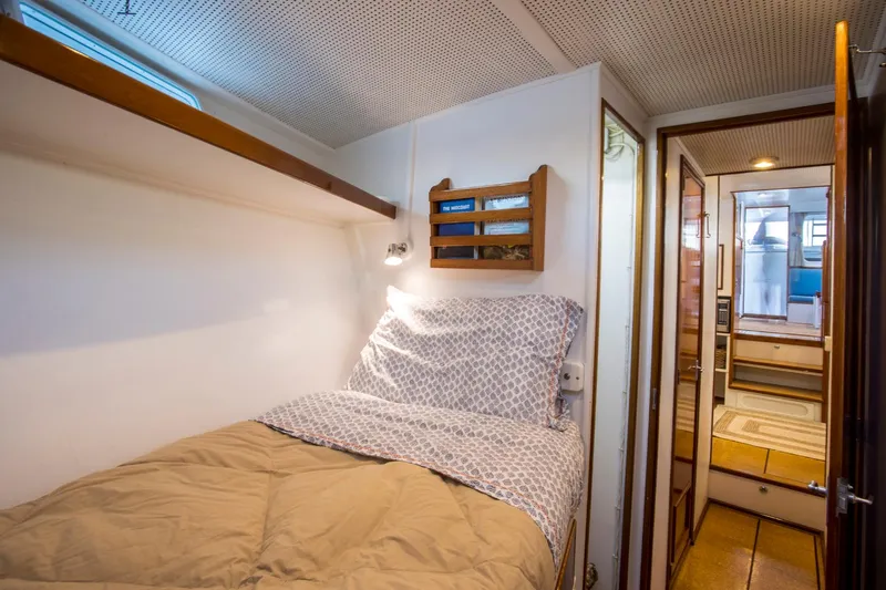 Huckins Yacht Corporation Yacht Photos Pics Cozy cabin interior of 1964 Huckins Out Islander 56 yacht with bed and wooden accents.