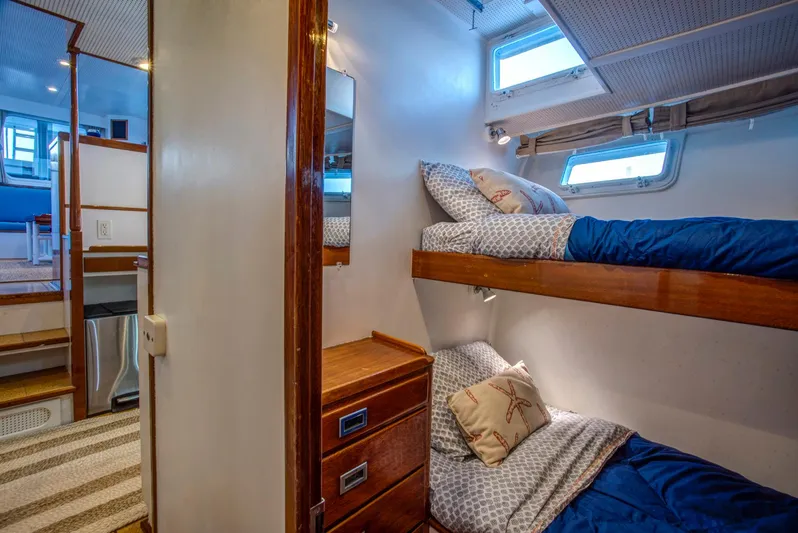 Huckins Yacht Corporation Yacht Photos Pics Interior of 1964 Huckins Out Islander 56 yacht with cozy bunk beds and wooden cabinetry.