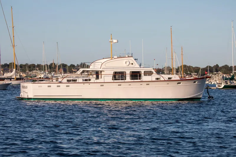 Huckins Yacht Corporation Yacht Photos Pics 1964 Huckins Out Islander 56 yacht on calm water, surrounded by sailboats.