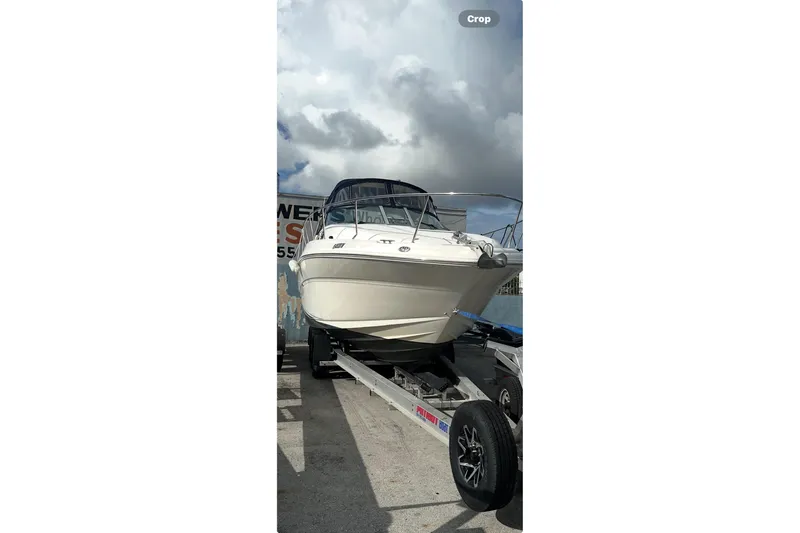  Yacht Photos Pics 2004 Sea Ray 320 Sundancer boat on trailer under cloudy sky.