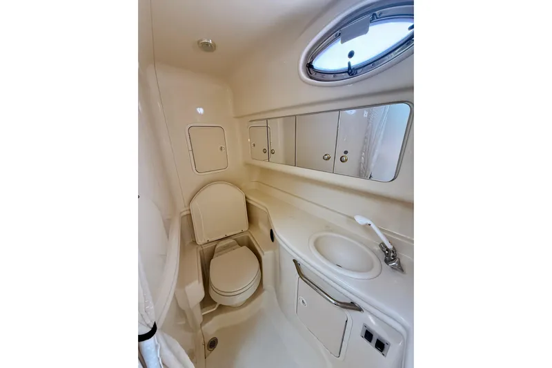  Yacht Photos Pics 2004 Sea Ray 320 Sundancer bathroom with toilet, sink, and storage cabinets.