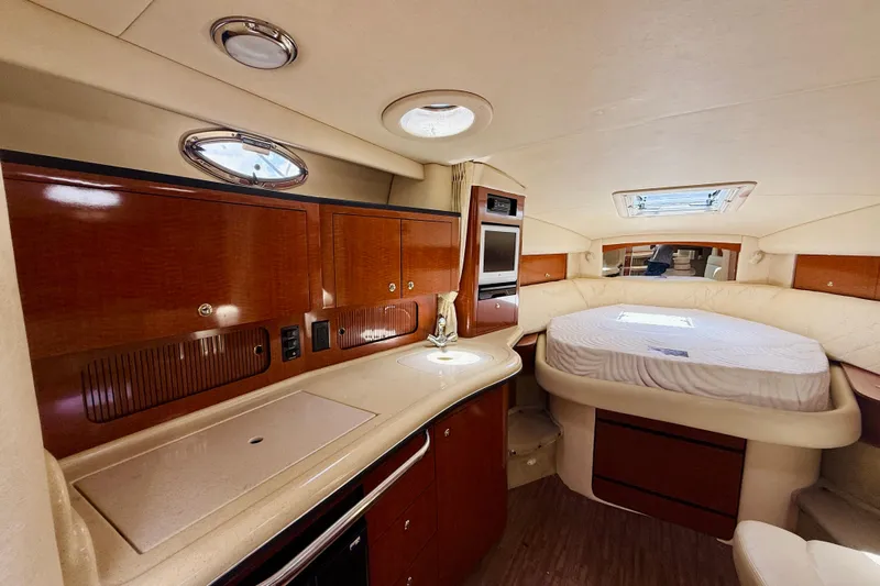  Yacht Photos Pics Luxurious interior of 2004 Sea Ray 320 Sundancer yacht with cozy bed and kitchenette.