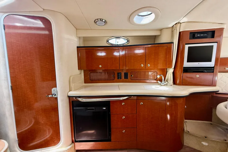  Yacht Photos Pics Interior of 2004 Sea Ray 320 Sundancer yacht with wood cabinetry and compact kitchen area.