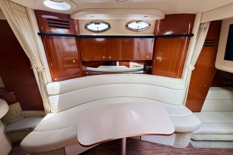  Yacht Photos Pics Interior of 2004 Sea Ray 320 Sundancer with curved seating and wooden cabinetry.