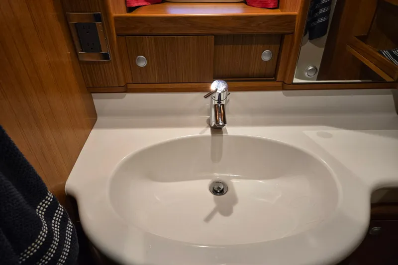 Kolea Yacht Photos Pics Luxurious bathroom sink in 2013 Ron Holland 50 yacht, featuring elegant wood cabinetry.