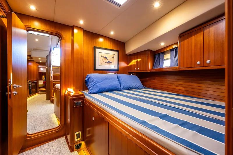 Kolea Yacht Photos Pics Luxurious 2013 Ron Holland 50 yacht cabin with wood paneling and striped bedding.