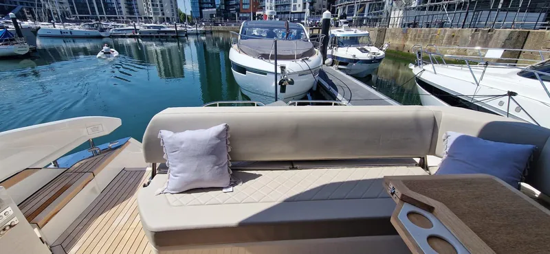 Seakeeper Gyro Yacht Photos Pics 2022 Fairline Targa 45 GT yacht interior with seating and table in a marina setting.