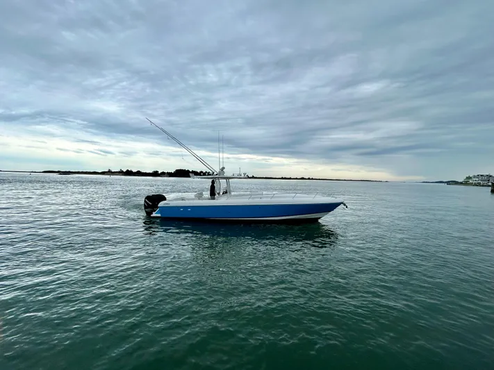 Overboard Yacht Photos Pics 2005 Intrepid 370 Cuddy boat on calm waters under cloudy sky.