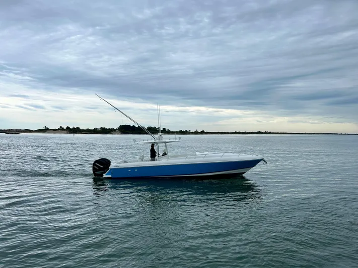 Overboard Yacht Photos Pics 2005 Intrepid 370 Cuddy boat cruising on calm waters under a cloudy sky.