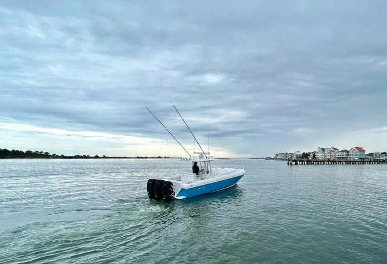 Overboard Yacht Photos Pics 2005 Intrepid 370 Cuddy boat cruising on calm waters under a cloudy sky.