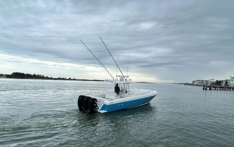 Overboard Yacht Photos Pics 2005 Intrepid 370 Cuddy boat on calm waters under cloudy sky.