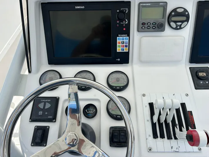 Overboard Yacht Photos Pics 2005 Intrepid 370 Cuddy helm with Simrad and Furuno navigation systems, steering wheel, and control levers.