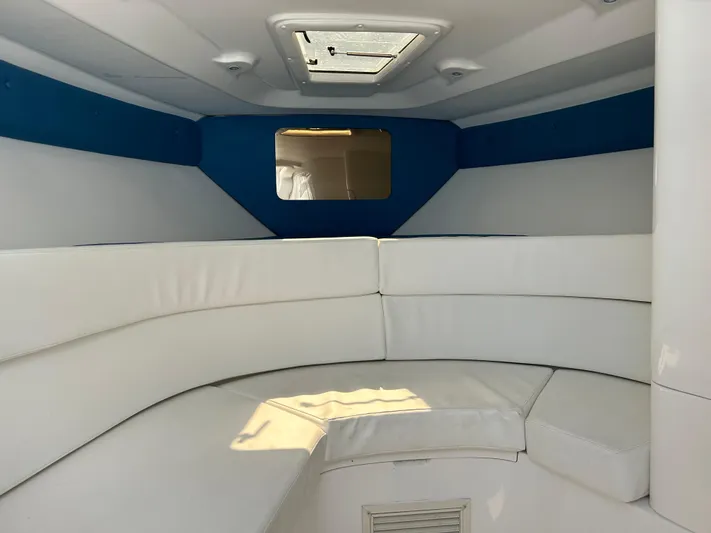 Overboard Yacht Photos Pics Interior of 2005 Intrepid 370 Cuddy with white cushioned seating and overhead hatch.