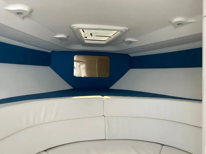 Overboard Yacht Photos Pics Interior cabin of a 2005 Intrepid 370 Cuddy boat with white and blue upholstery.