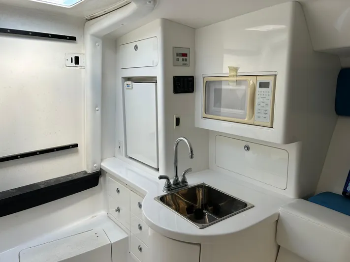 Overboard Yacht Photos Pics Compact kitchen area in a 2005 Intrepid 370 Cuddy boat with sink, microwave, and storage.