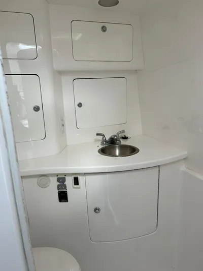 Overboard Yacht Photos Pics 2005 Intrepid 370 Cuddy boat interior with sink and storage cabinets