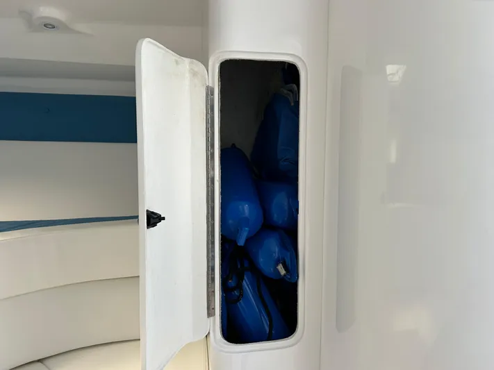 Overboard Yacht Photos Pics Storage compartment on a 2005 Intrepid 370 Cuddy boat with blue fenders inside.