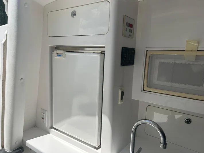 Overboard Yacht Photos Pics 2005 Intrepid 370 Cuddy boat galley with fridge, microwave, and sink.