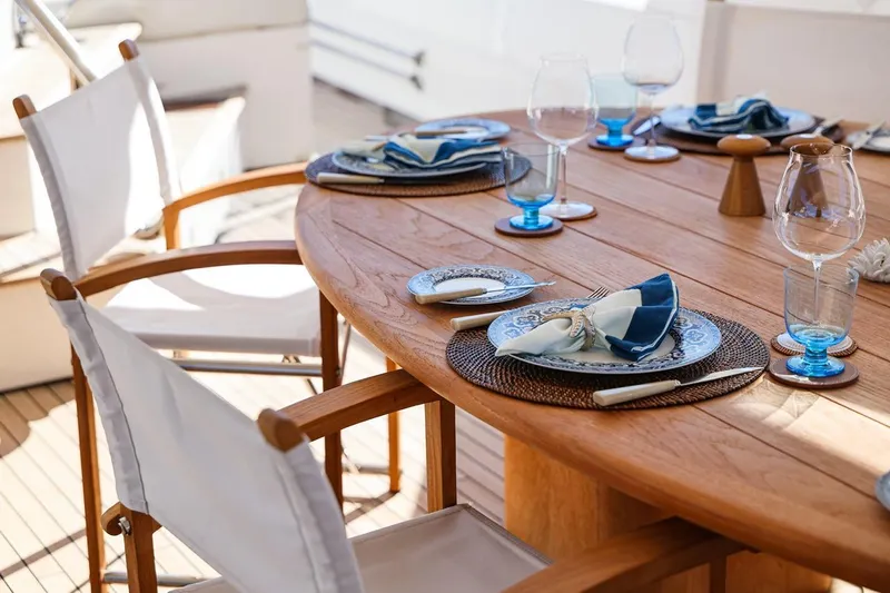 Frivolous Yacht Photos Pics Elegant dining setup on 2009 Sunseeker 34 Metre Yacht, featuring wooden table and stylish tableware.