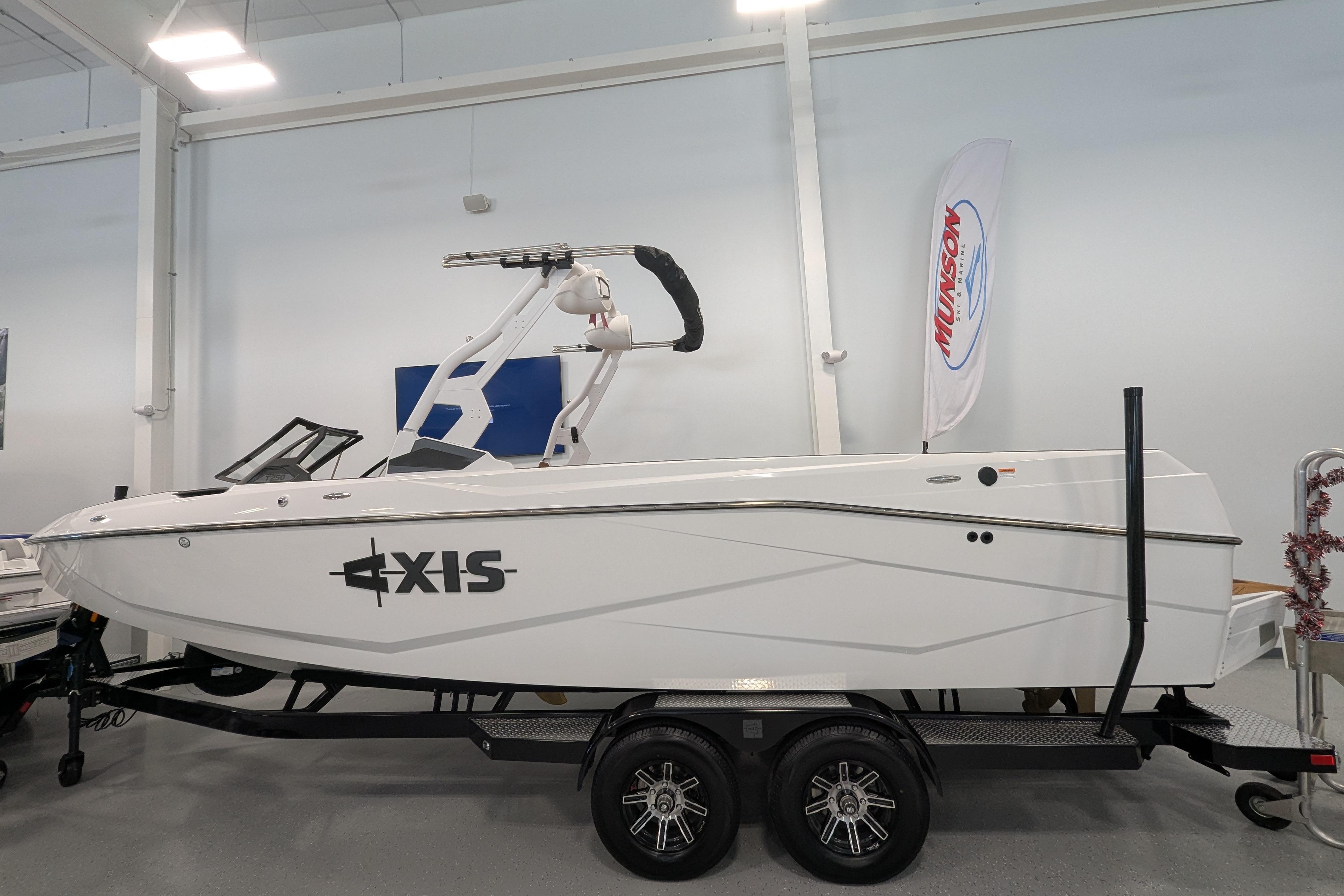 2026 Axis T250 boat on trailer in showroom, featuring sleek white design.