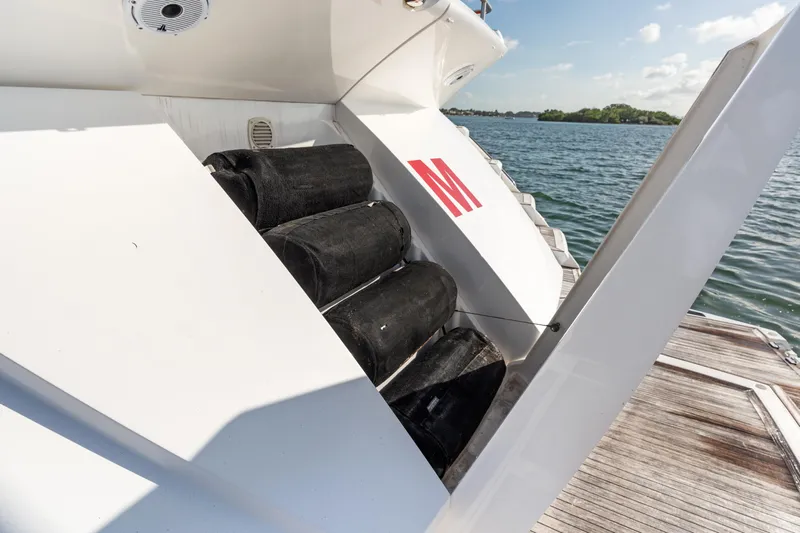 Gem Yacht Photos Pics 2014 Sunseeker 68 Sport Yacht docked, featuring storage compartment with black fenders.