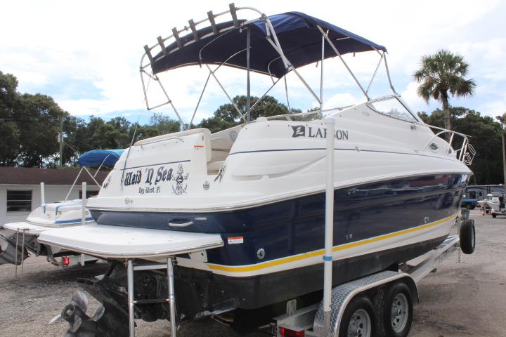 2005 Larson Cabrio 240 boat on trailer with blue canopy.