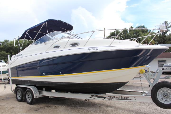 2005 Larson Cabrio 240 boat on a trailer, blue and white exterior.